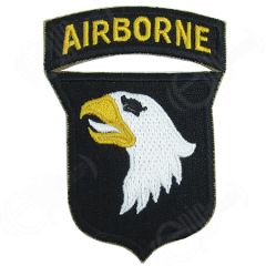 Shield shaped dark brown embroidered patch with right facing eagle face with black eye, yellow beak, and white tongue. Attached to the top of the shied is a dark brown arch with AIRBORNE in yellow