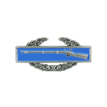 Front of Combat Infantryman 1st Award showing right facing silver coloured rifle, on horizontal rectangular blue background on top of a silver coloured wreath