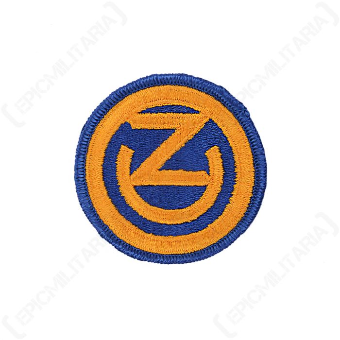 Front view of circular, dark blue embroidered patch with a gold ring around the inside, the letter 'Z' and a half circle in the centre