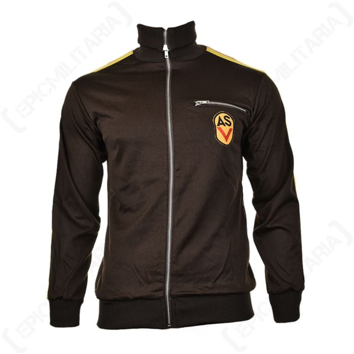 Front of dark brown training jacket with silver zip. On left chest there is a pocket with a silver zip, and underneath it there is a yellow patch with AS in black, and a red chevron under the letters.