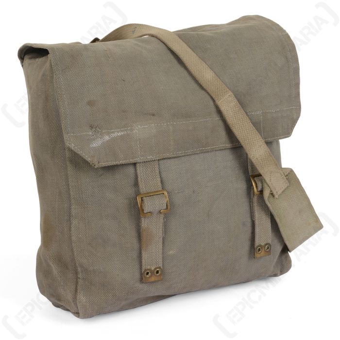 Front view of a field grey canvas bag with a flap top closure with two closure straps. The bag is turned slightly to the left