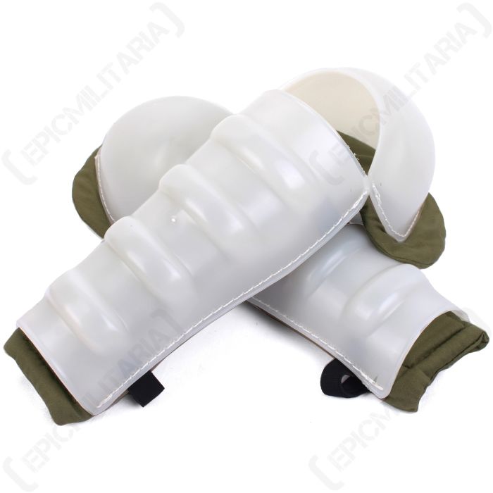 Front view of white plastic knee protectors with khaki green padding underneath. The top knee protector is placed diagonally over the top one