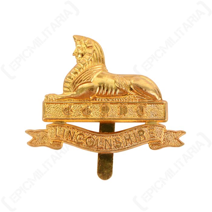 Front of gold coloured British Lincolnshire Regiment cap badge featuring a sphinx and scroll with LINCONLSHIRE written inside