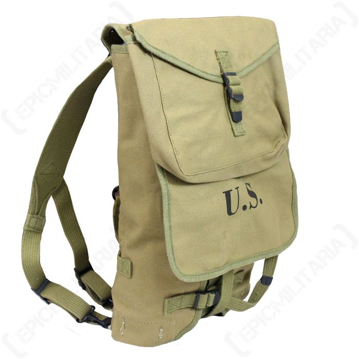 Side view of khaki US backpack, with a pouch attached to the main closure flap. 'US' is stamped on the main flap. There are two straps on the back of the bag.