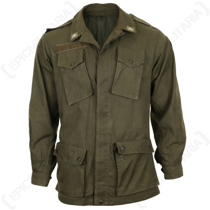 Front view of olive drab Italian army field jacket, with an Italian star on each point of the turned-down collar. There are two chest pockets and two pockets further down the front of the jacket. There is a hook and loop strip above the right pocket.