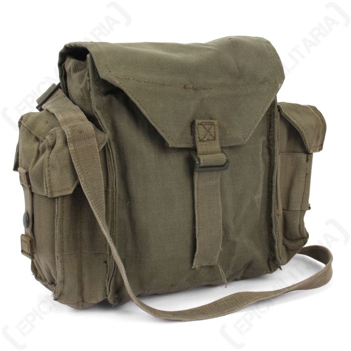 Side view of green canvas rucksack with an additional pouch on either side, and green canvas shoulder strap