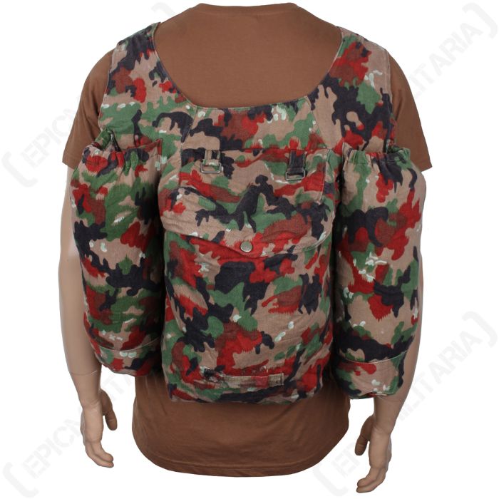 Front of camouflage rucksack with a drawstring pouch on each side of the main bag. The bag is worn by a mannequin wearing a brown t-shirt 