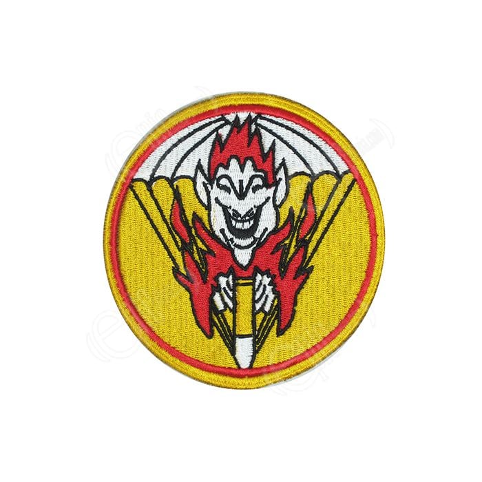 Circular embroidered yellow patch with red detail, including a white cartoon face with red hair, surrounded by red cartoon flames