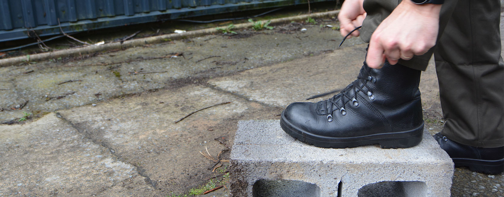 close up of person tying the laces of a military boot.