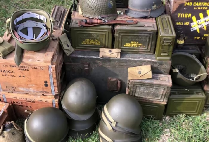 A stack of ammunition crates and green helmets