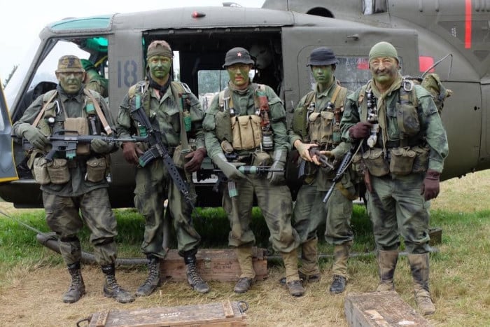 5 men standing at the door of a helicopter