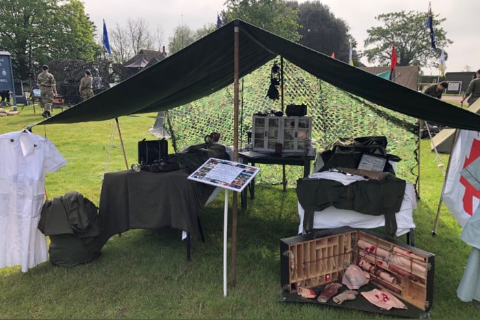 A military tent with two beds and medical equipment nearby
